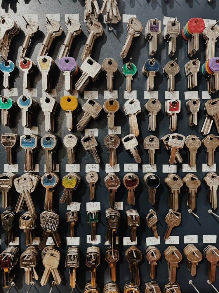 A shop board of tagged key blanks hung in rows, each with its code
