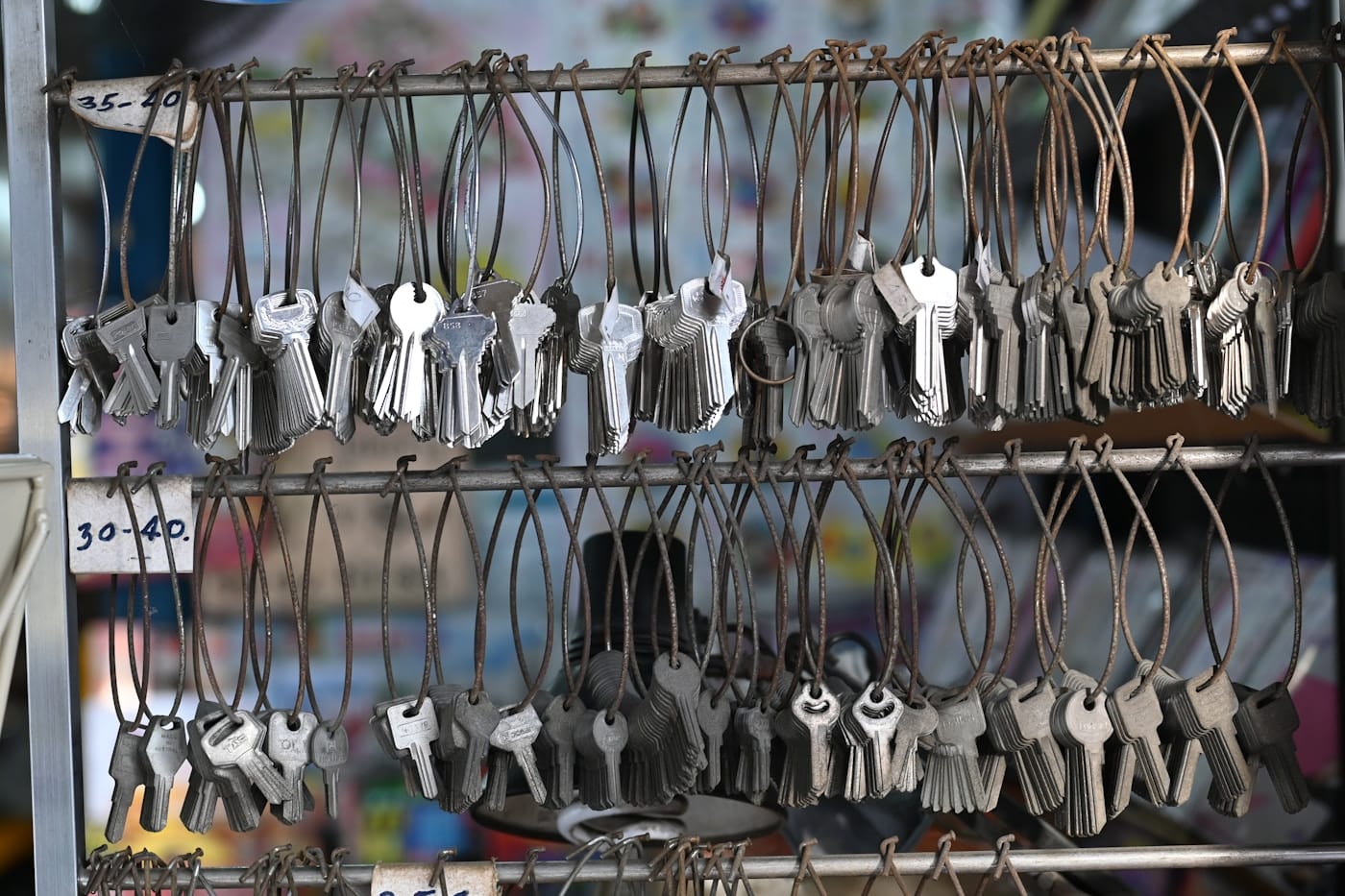 Racks of uncut key blanks hanging on wire loops in a locksmith's shop